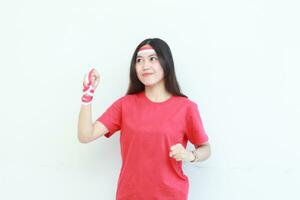 portrait of beautiful asian woman wearing red outfit posing in spirit celebrating Indonesia independence day photo