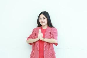 portrait of beautiful asian woman wearing red outfit with namaste gesture while smiling photo