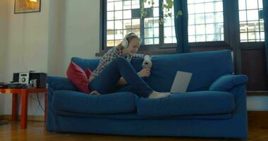 Woman on the sofa at home having video chat