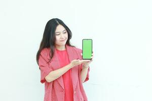 portrait of beautiful asian woman wearing red outfit holding mobile phone and smiling photo