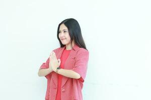 portrait of beautiful asian woman wearing red outfit with namaste gesture while smiling photo