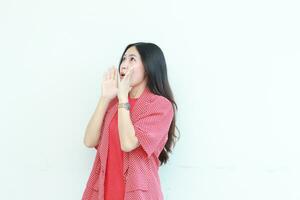 portrait of beautiful asian woman wearing red outfit with whispering gesture photo