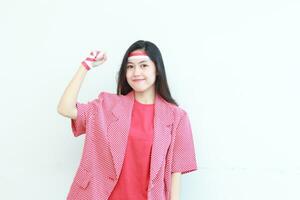 portrait of beautiful asian woman wearing red outfit posing in spirit celebrating Indonesia independence day photo