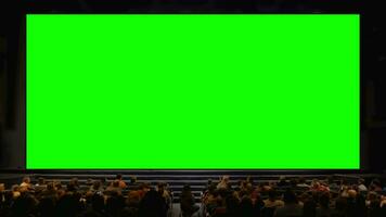 People in the auditorium with chroma key screen video