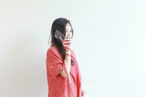 portrait of beautiful asian woman wearing red outfit celebrating Indonesia independence day while calling with smiling expression photo