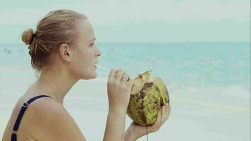 mulher em a de praia bebendo a partir de coco video