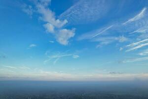 Most Beautiful and Best High Angle Dramatical Colourful Sky Footage from Above The Clouds. The Fast Moving Clouds During Sun rising Early in the Morning over Luton City of England UK photo