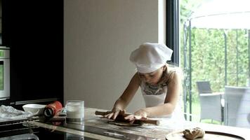 menina do 6 anos velho é preparando pizza com tomates molho e tolet cebola dentro frente do dela assinantes. video