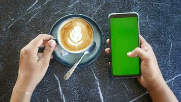 segurando uma CPU do café e usando inteligente telefone com verde tela . video