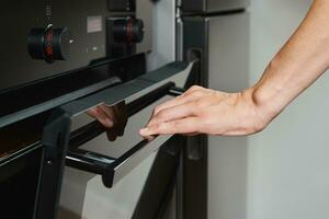 Female open electric oven door photo