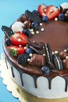 Cake decorated with strawberry and chocolate on blue background photo