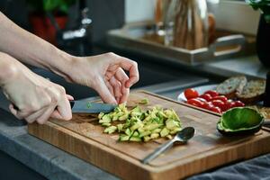 Woman chopping avocado for breakfast toasts photo