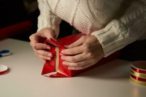 Woman packaging gift box in craft paper, Present for christmas surprise photo