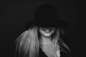 Beautiful blonde woman wearing a hat, artistic film portrait in black and white for fashion campaign and beauty brand photo