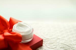 Luxury face cream jar and red gift box photo