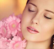 Beauty, holiday and bridal makeup, beautiful woman with pink flowers bouquet as cosmetics, perfume and face skincare photo