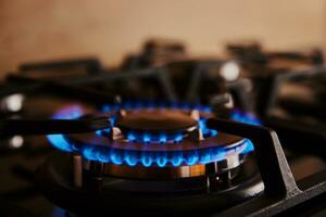 Gas stove with flame on burner, close up photo