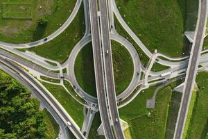 Cars moving on transport road junction in city, aerial view photo