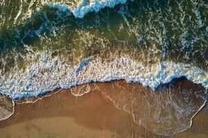 Coastline with sea waves and sand beach, top view photo