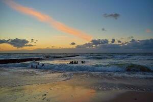 báltico mar playa con olas a puesta de sol foto