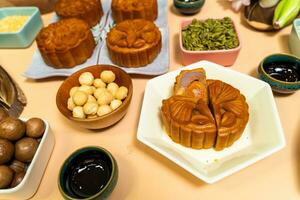 a tasty round moon cakes at mid autumn festival. Flat lay mid autumn festival food and drink on sweet beige background. photo