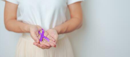 Woman holding purple Ribbon for Violence, Pancreatic, Esophageal, Testicular cancer, Alzheimer, epilepsy, lupus, Sarcoidosis and Fibromyalgia. Awareness month and World cancer day concept photo