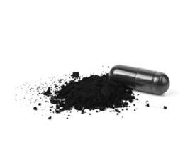 Charcoal capsules and powder isolated on white. photo