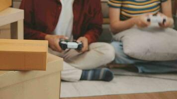 en mouvement à une Nouveau appartement. content jeunes mariés acheté leur premier maison, supporter dans le vivant pièce parmi le des boites, tenir papier carton des boites dans leur mains, préparer à déballer choses, Regardez à le caméra, sourire video