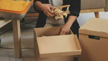 en mouvement à une Nouveau appartement. content jeunes mariés acheté leur premier maison, supporter dans le vivant pièce parmi le des boites, tenir papier carton des boites dans leur mains, préparer à déballer choses, Regardez à le caméra, sourire video