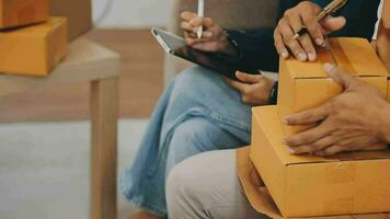 joven hembra vestir diseñador sentado a lugar de trabajo con ordenador portátil. pequeño negocio dueño, emprendedor, vendedor comprobación comercio electrónico ropa Tienda pedidos. compras concepto. Moda estudio. video