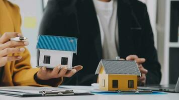 Female woman hands holding home model, small miniature white toy house. Mortgage property insurance dream moving home and real estate concept video