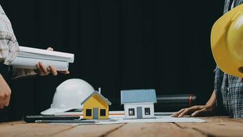Image of team engineer checks construction blueprints on new project with engineering tools at desk in office. video