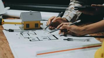 Image of team engineer checks construction blueprints on new project with engineering tools at desk in office. video