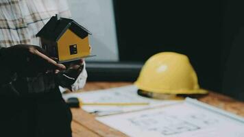 Image of team engineer checks construction blueprints on new project with engineering tools at desk in office. video