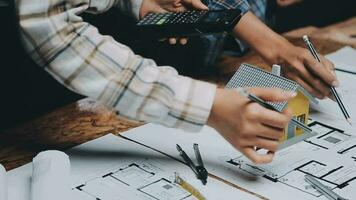 Image of team engineer checks construction blueprints on new project with engineering tools at desk in office. video