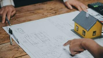 Image of team engineer checks construction blueprints on new project with engineering tools at desk in office. video