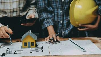 Image of team engineer checks construction blueprints on new project with engineering tools at desk in office. video