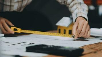Image of team engineer checks construction blueprints on new project with engineering tools at desk in office. video