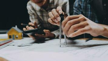 Image of team engineer checks construction blueprints on new project with engineering tools at desk in office. video