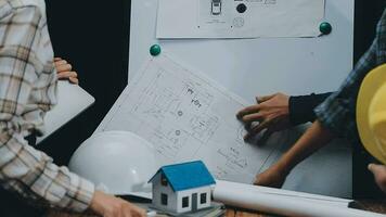 Image of team engineer checks construction blueprints on new project with engineering tools at desk in office. video