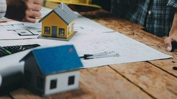 Image of team engineer checks construction blueprints on new project with engineering tools at desk in office. video