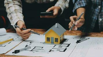 Image of team engineer checks construction blueprints on new project with engineering tools at desk in office. video