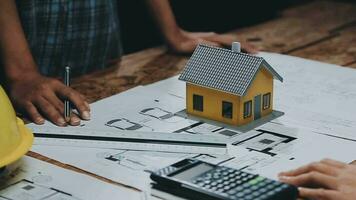 Image of team engineer checks construction blueprints on new project with engineering tools at desk in office. video