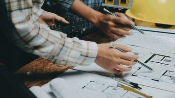 Image of team engineer checks construction blueprints on new project with engineering tools at desk in office. video