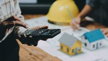 Image of team engineer checks construction blueprints on new project with engineering tools at desk in office. video