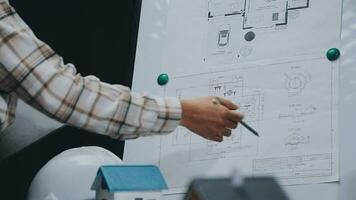 Image of team engineer checks construction blueprints on new project with engineering tools at desk in office. video