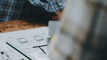 Image of team engineer checks construction blueprints on new project with engineering tools at desk in office. video