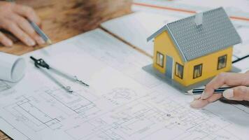 Image of team engineer checks construction blueprints on new project with engineering tools at desk in office. video