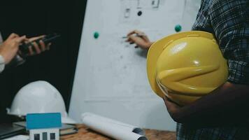 Image of team engineer checks construction blueprints on new project with engineering tools at desk in office. video