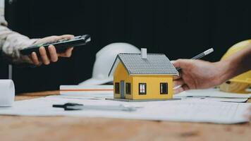 Image of team engineer checks construction blueprints on new project with engineering tools at desk in office. video